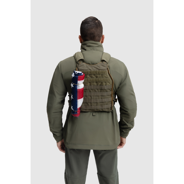 Back photo of the Tomahawk Performance Crosswind Jacket, a tactical windbreaker, worn under a carrier in Ranger Green color way.
