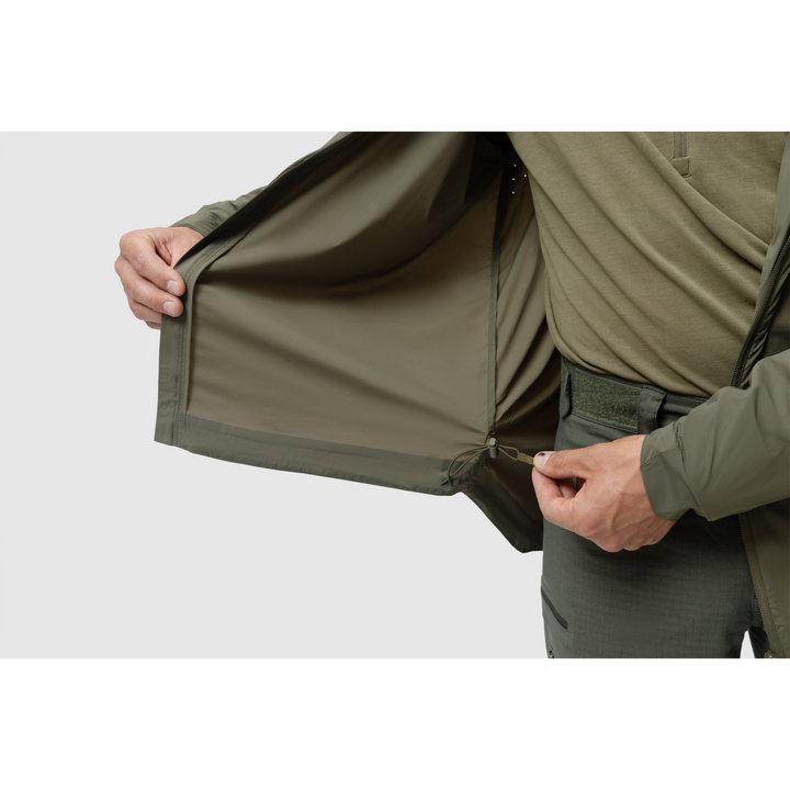 Photo of the Tomahawk Performance Crosswind Jacket's interior lining around the hem including adjustable hem drawstring in Ranger Green color way. Laser perforation for ventilation also shown.