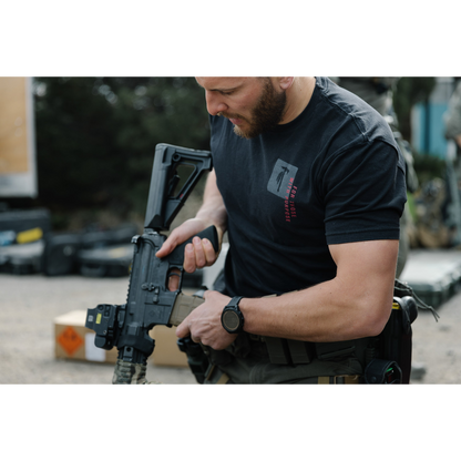 Photo of a man wearing the Tomahawk Performance FTWP T-Shirt SS handling a gun.
