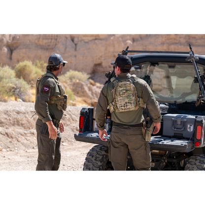 Two men wearing the Tomahawk Performance HW / Combat Uniform loading gear out of a side-by-side vehicle.