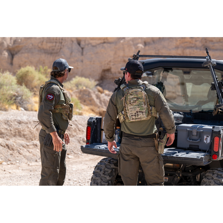 Two men wearing the Tomahawk Performance HW / Combat Uniform loading gear out of a side-by-side vehicle.